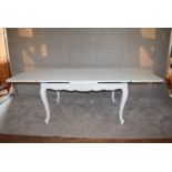 A Louis XV style pale blue distressed painted draw leaf dining table on carved cabriole supports L.