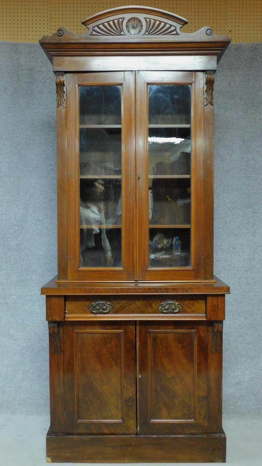 A late 19th century mahogany bookcase with glazed doors above frieze drawer above panel doors