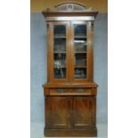 A late 19th century mahogany bookcase with glazed doors above frieze drawer above panel doors
