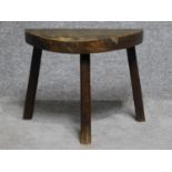 An antique oak three legged milking stool.