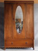 A mid 20th century oak wardrobe with hanging space above base drawer. H.192 W.118 D.44cm