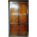 A Georgian mahogany and satinwood strung two section floor standing full height corner cupboard with