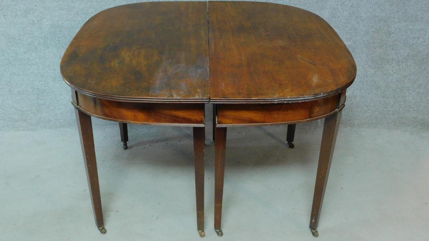 A Georgian mahogany D-end extending dining table on square tapering supports. H.76 L.181 W.55cm (
