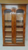 A 19th century mahogany full height floor standing bookcase with a pair of glazed doors enclosing