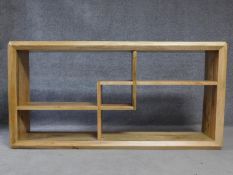 A contemporary oak sideboard with geometric interlinked design open shelves. H.92 W.36 L.180cm