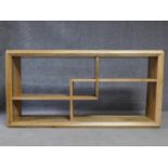 A contemporary oak sideboard with geometric interlinked design open shelves. H.92 W.36 L.180cm