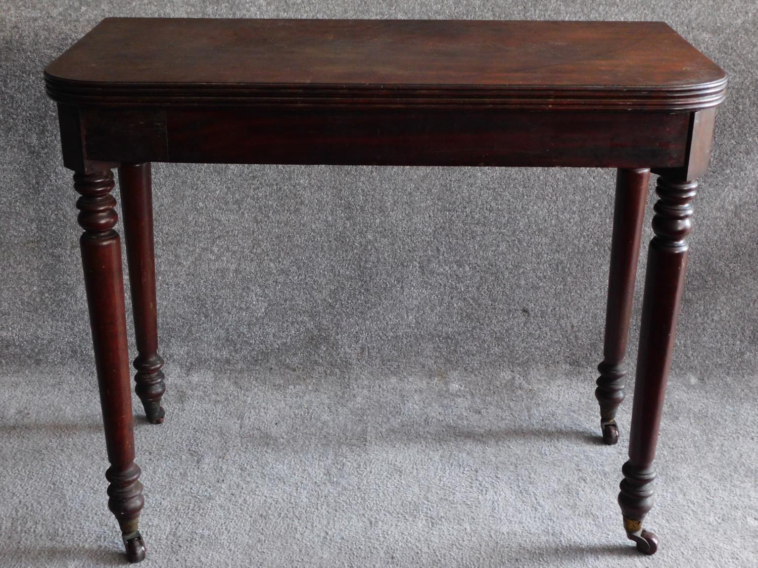 A 19th century mahogany foldover top tea table on turned tapering supports. H.74 W.45 D.92cm