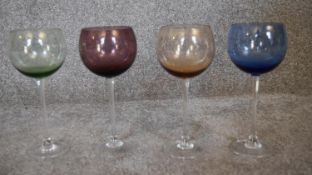 A set of four crystal coloured wine glasses. H.23cm