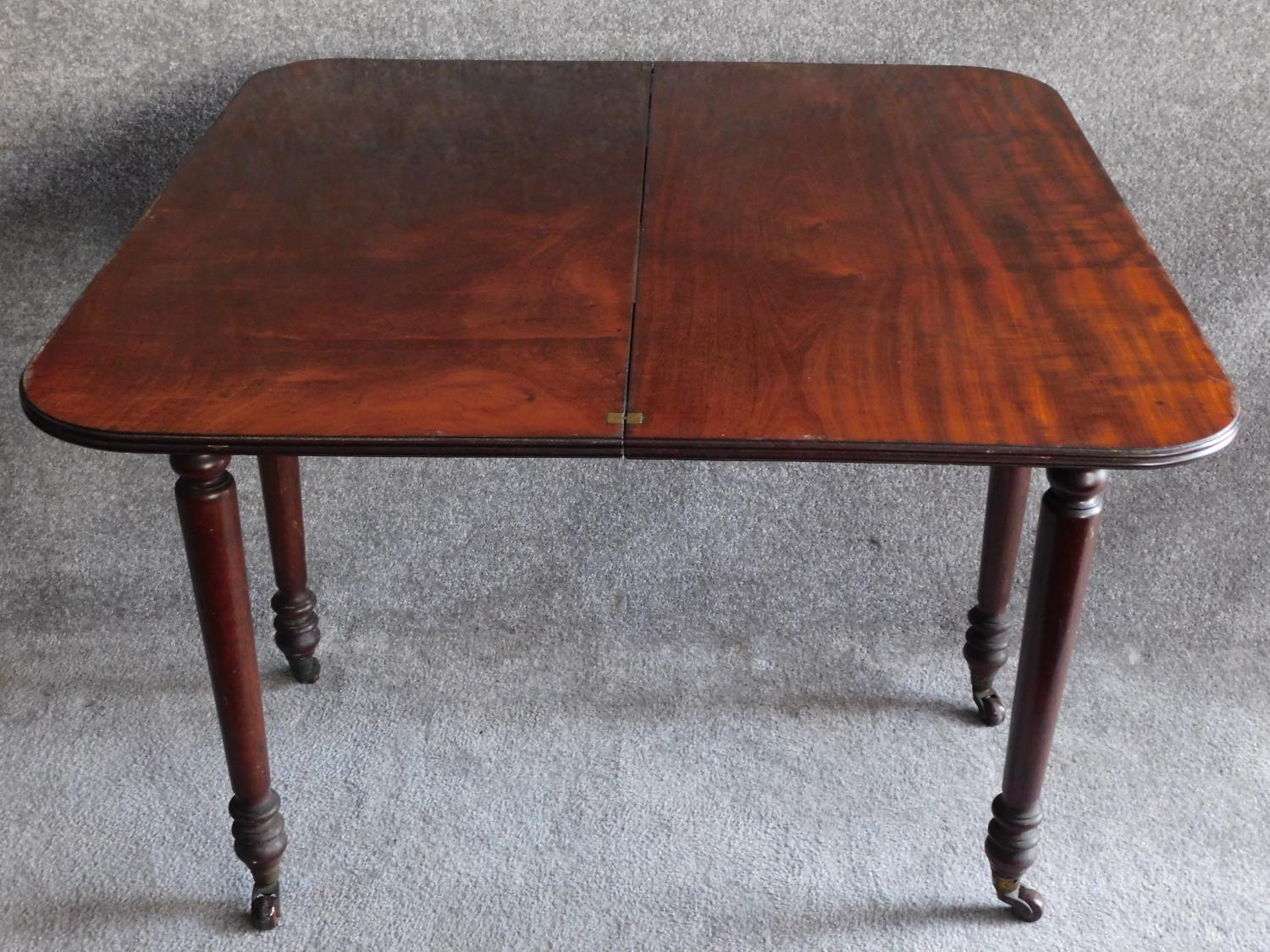 A 19th century mahogany foldover top tea table on turned tapering supports. H.74 W.45 D.92cm - Image 3 of 4