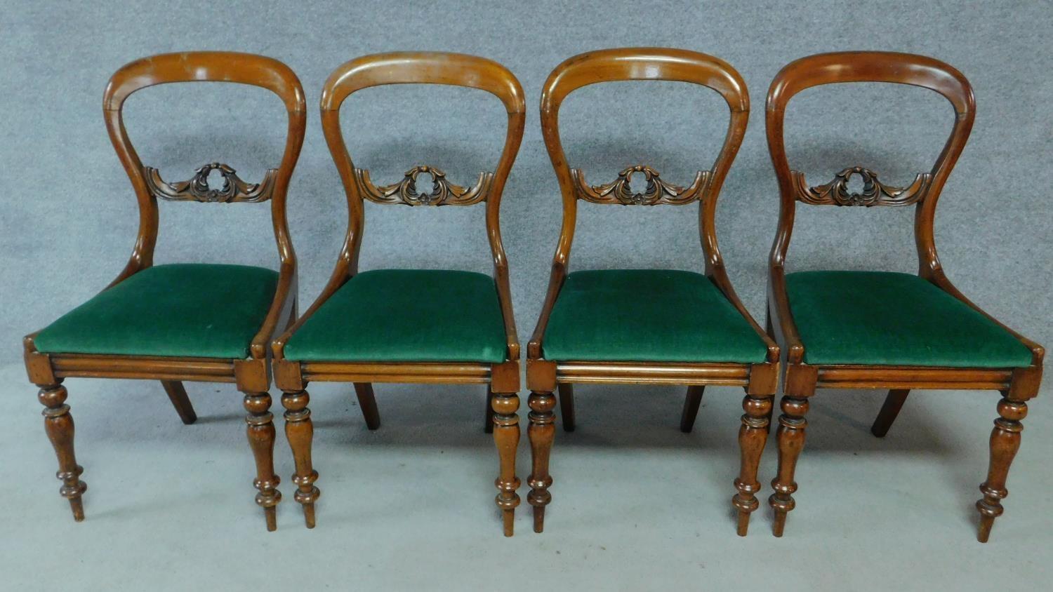 A set of four Victorian mahogany balloon back dining chairs on turned tapering supports. H.87cm