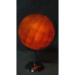 A vintage illuminated world globe lamp. Glass shade covered with paper globe sections. On a polished