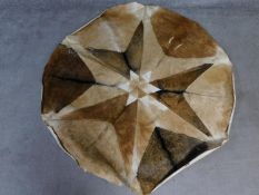 A circular goat skin rug with star pattern. 148x148cm
