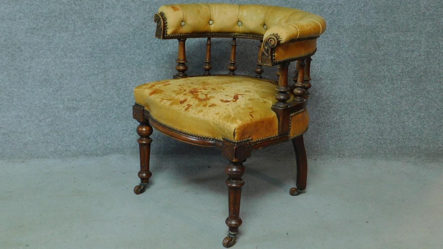 A late 19th century mahogany framed leather upholstered buttoned back library tub armchair on turned