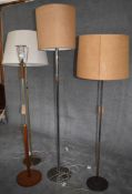 A mid 20th century vintage teak standard lamp and three others all in cream and beige lampshades.