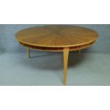 A large Art Deco style zebra wood dining table with circular segment veneered top on three