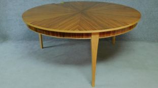 A large Art Deco style zebra wood dining table with circular segment veneered top on three