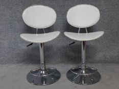 A pair of contemporary leather upholstered rise and fall swivel action bar stools on chrome pedestal