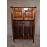 A late Victorian walnut music cabinet with panel doors above Canterbury section. H.130 x 76cm (
