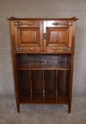 A late Victorian walnut music cabinet with panel doors above Canterbury section. H.130 x 76cm (