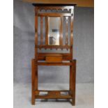 A 19th century Art Nouveau walnut hallstand with central mirror above glove compartment with