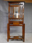 A 19th century Art Nouveau walnut hallstand with central mirror above glove compartment with