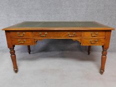 A Victorian walnut writing table with leather insert top and long central frieze drawer and four