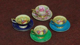 Four gilded Ainsley tea cups and saucers with fruit decoration along with one with rose flower