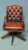 A Georgian style mahogany framed buttoned back leather upholstered office swivel desk armchair. H.