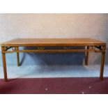 A Chinese hardwood rattan topped dining table raised on circular section supports. Possibly retailed
