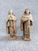 Two antique painted terracotta figures. One of a monk holding a candle and a bible and the other