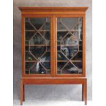 A Georgian style mahogany library bookcase with astragal glazed doors on square section supports.