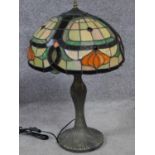 A Tiffany style iridescent stained glass table lamp. Shade has an Art Nouveau floral design with