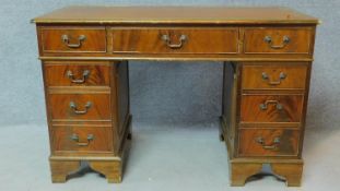 A Georgian style flame mahogany desk with long frieze drawer and eight short drawers. H.79 W.122 D.