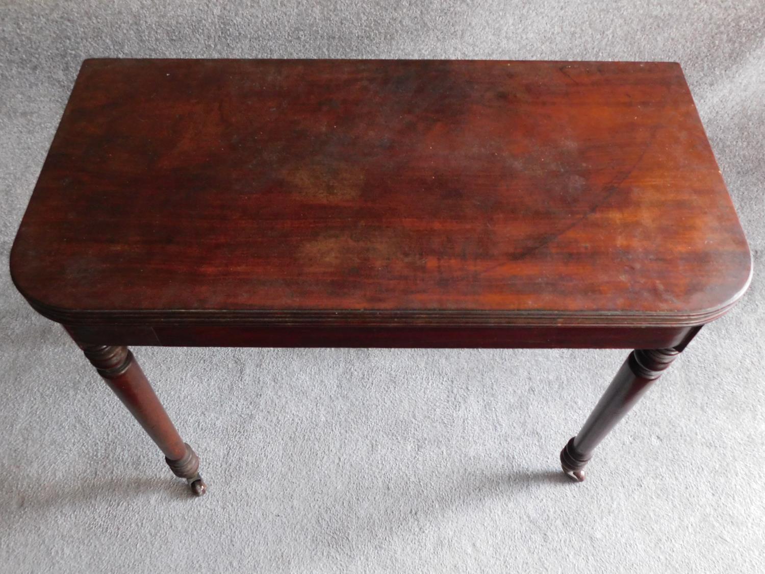 A 19th century mahogany foldover top tea table on turned tapering supports. H.74 W.45 D.92cm - Image 2 of 4