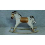 A vintage fabric covered rocking horse with brown leather saddle, wooden muzzle and fabric mane. H.