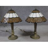 A pair of Tiffany style stained glass table lamps. Lamps have a geometric repeating design with a