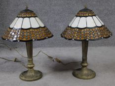 A pair of Tiffany style stained glass table lamps. Lamps have a geometric repeating design with a