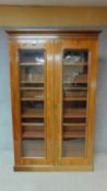 A 19th century mahogany full height floor standing bookcase with a pair of glazed doors enclosing