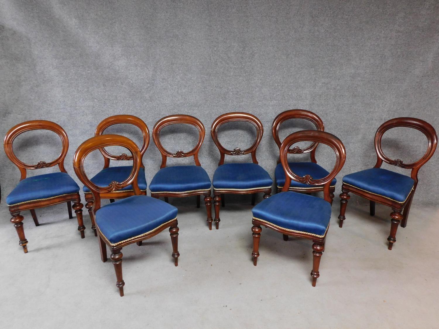 A set of eight Victorian mahogany balloon back dining chairs on turned tapering supports. H.91cm