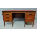A mid 20th century teak desk with leather top on semi circular supports. H.73 W.137 D.76cm