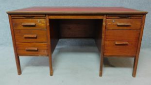 A mid 20th century teak desk with leather top on semi circular supports. H.73 W.137 D.76cm