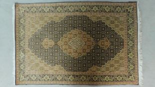 A Tabriz rug with central double pendant medallion with repeating petal motifs , complemented by a