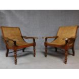 A pair of Colonial teak framed reclining planter's chairs with foldout foot rests on turned tapering