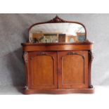 A Victorian mahogany chiffonier with well carved arched mirror above frieze drawer and panel doors