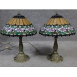 A pair of Tiffany style coloured glass table lamps. Shades have rose and foliate design and the