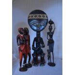 A carved African seated tribal figure and other similar carved figures. H.45cm