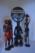 A carved African seated tribal figure and other similar carved figures. H.45cm