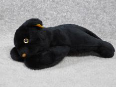 A Steiff vintage toy of a young black panther. With label and gold button. Plastic eyes. W.31cm