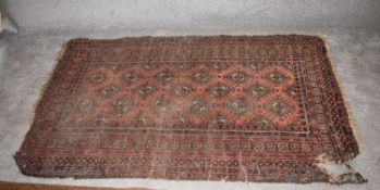 A Bokhara style rug with elephant pad motifs on a terracotta field encompassed with mutli