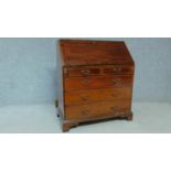 An Edwardian mahogany bureau with fitted compartment above two short over three long drawers on